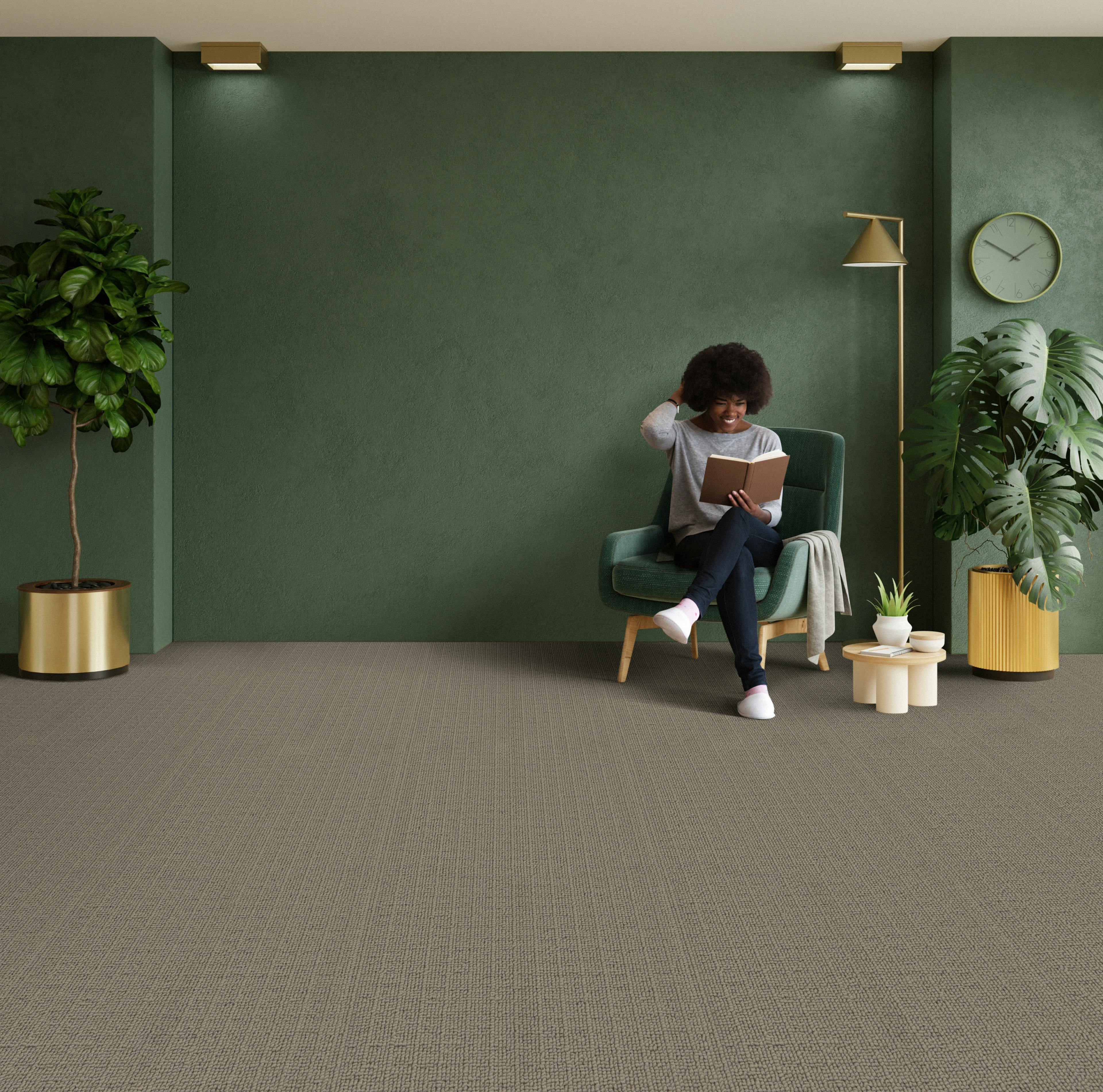 Lady relaxing in a room with the 100% recycled yarn loop pile carpet